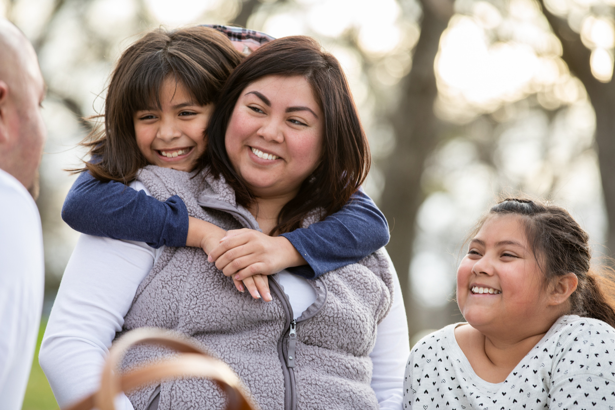 Immigrant family staying together, happy woman with her husband and young step daughters