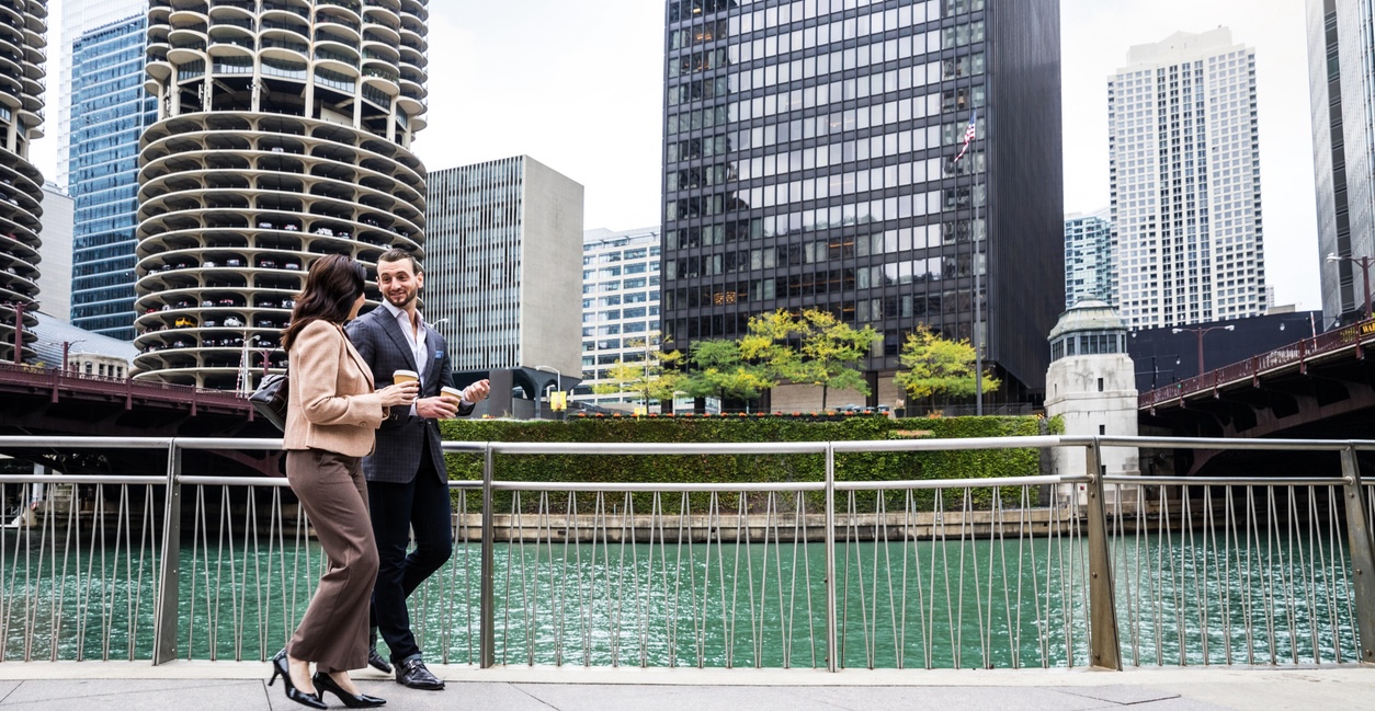 Immigration Compliance Lawyers for Chicago Employers, Couple of business people standing outside the office buildings in downtown waiting for a meeting in Chicago, USA